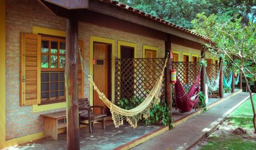 a house with hammocks on the side of it at SR Farm Hotel in Brotas