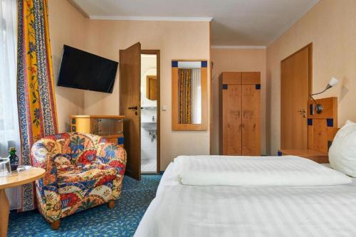 a hotel room with a bed and a chair at Garden Depandance Am Bach in Kurort Altenberg