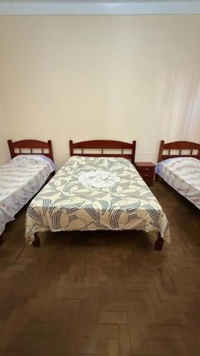 a bedroom with two beds and a comforter at Pousada Casa Grande in São Lourenço