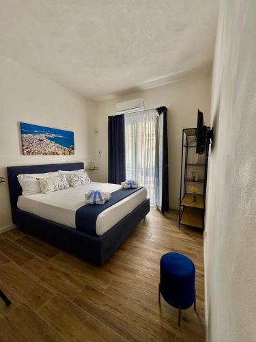 a bedroom with a bed and a blue stool at Matri Mia in Trapani