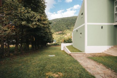 a white house with a grass yard and trees at Dolce Luxury Villa in Nižepole