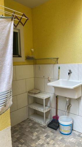 a bathroom with a sink and a white sink at Itaipuaçu Central in Maricá