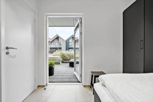 a bedroom with a door leading to a patio at 9929-Hvide-Sande-Langsand-194-stuen in Hvide Sande