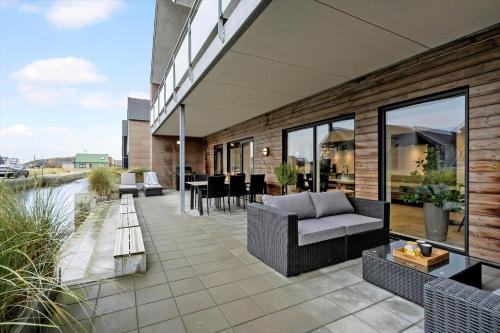 a patio with a couch and chairs on a building at 9929-Hvide-Sande-Langsand-194-stuen in Hvide Sande