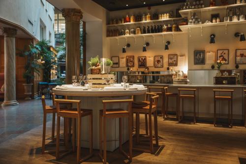 a bar in a restaurant with chairs around a table at Hotel Kung Carl, WorldHotels Crafted in Stockholm