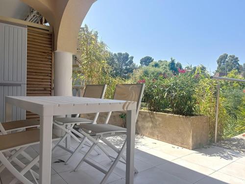 une table blanche et des chaises sur une terrasse dans l'établissement 5-room studio - sea view- terrace - parking, à Saint-Raphaël