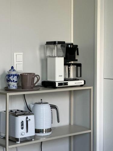 a shelf with a coffee maker and a blender at Mountain and Sea View Svolvær in Svolvær