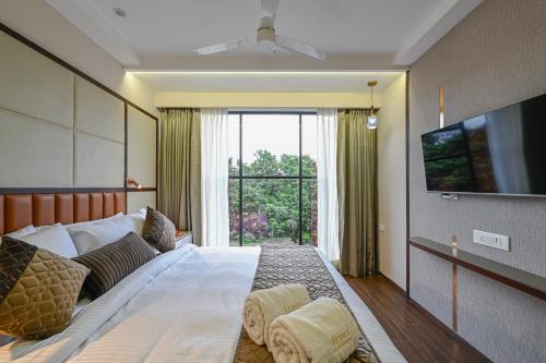a bedroom with a large bed and a large window at Hotel Grand Girdhar Premier in Indore