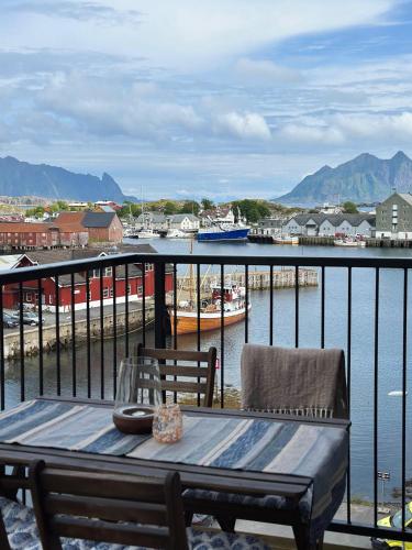 a balcony with a table and chairs and a harbor at Mountain and Sea View Svolvær in Svolvær