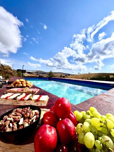 a table with fruits and vegetables next to a swimming pool at Zlatibor Wild nest Rabbit Lux in Zlatibor