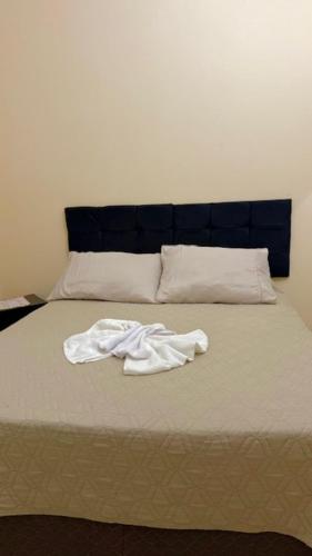 a bed with a pile of white sheets on it at Pousada Casa Grande in São Lourenço