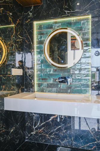 a bathroom with a sink and a mirror at Hotel Grand Girdhar Premier in Indore