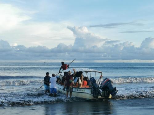 a group of people on a boat on the beach at Chowa lodge in Nuquí