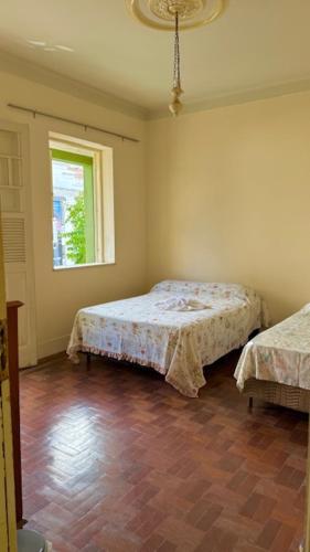 a bedroom with two beds and a window at Pousada Casa Grande in São Lourenço