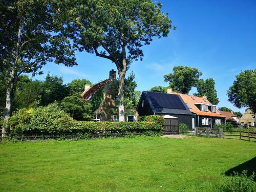 an old house with a tree and a yard at Lanterfant in Nes