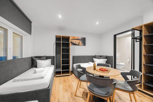 a room with two beds and a table and chairs at Creativ Wohnen Apartmenthaus Forstinning in Forstinning