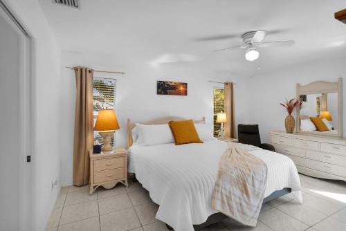 a white bedroom with a bed and a mirror at Private Pool Home with Backyard Oasis & Family-Friendly Comfort in Cape Coral FL in Cape Coral