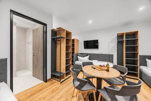 a living room with a table and chairs and a couch at Creativ Wohnen Apartmenthaus Forstinning in Forstinning