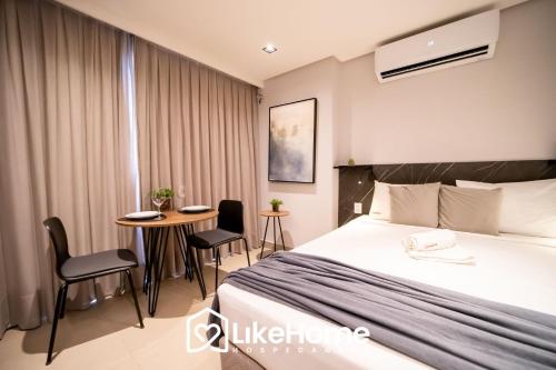 a hotel room with a bed and a table and chairs at Edifício Way Tambaú in Tambaú