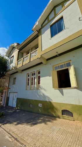 a large building with a window and a balcony at Pousada Casa Grande in São Lourenço