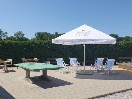 a table and chairs with an umbrella and a table and chairs at Penzion Apartmány Libošovice in Libošovice