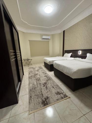 a hotel room with two beds and a tv at فـالـي ريزيدنـس - Valley Residence in Al Baha