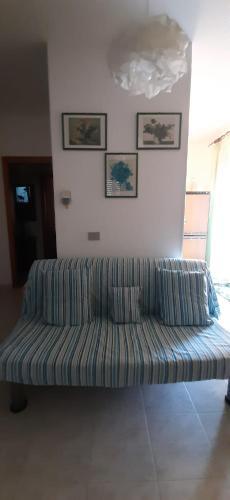 a couch sitting in a living room next to a wall at Casa vacanza Colle Renazzo con terrazzo in collina 15 min. dal mare in Mafalda