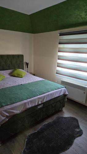 a bedroom with a large bed and a window at Apartman Tanja in Nova Varoš