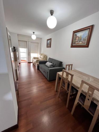 a living room with a table and a couch at Apartamento Alameda de Noia in Noya