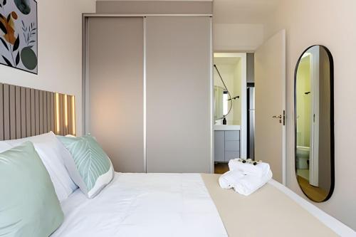 a bedroom with a white bed and a mirror at Today Perdizes in Sao Paulo