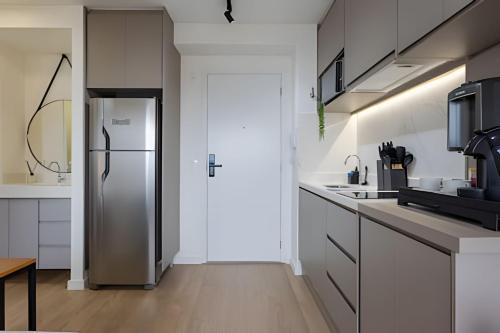 a kitchen with a refrigerator and white cabinets at Today Perdizes in Sao Paulo