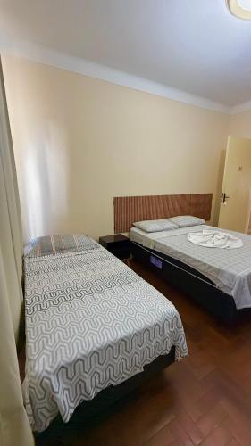 two beds sitting in a room withthritisthritisthritisthritisthritisthritisthritisthritisthritis at Pousada Casa Grande in São Lourenço