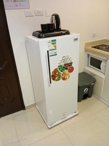 a white refrigerator in a kitchen next to an oven at شقق جديل للشقق المخدومة in Taif