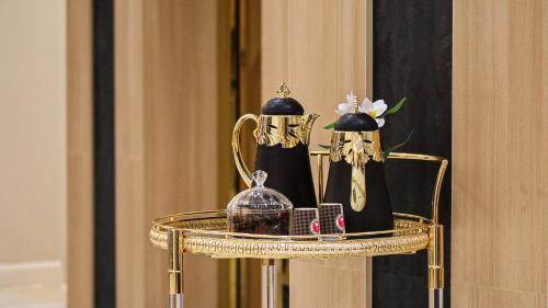 a gold table with two perfume bottles and a mirror at القصر المميز للأجنحه الفندقيه in Abha