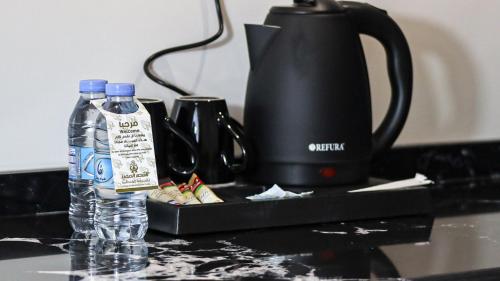 a bottle of water sitting next to a tea kettle at القصر المميز للأجنحه الفندقيه in Abha