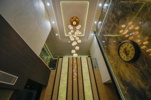 a hallway with a chandelier and a clock on the ceiling at Hotel Grand Girdhar Premier in Indore