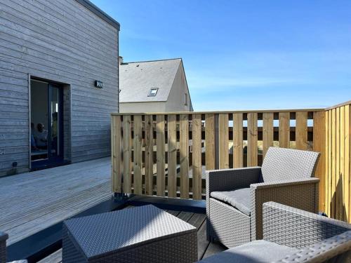a patio with chairs and tables on a deck at Beach House in Port-Bail-sur-Mer