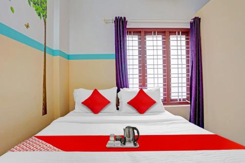 a bedroom with a bed with red and white pillows at SPOT ON The New View Regency in Trivandrum
