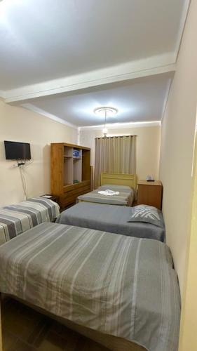 a hotel room with two beds in a room at Pousada Casa Grande in São Lourenço