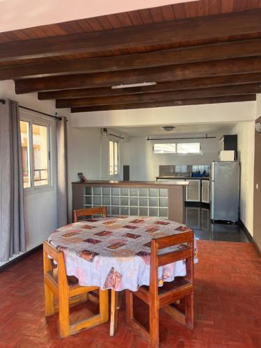 a dining room with a table and a kitchen at Appartement Antananarivo - Palais de la Reine, Rova in Mandriankeniheny