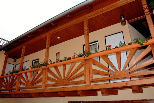 a balcony of a house with flowers on it at Tornácos Vendégház in Vlăhiţa