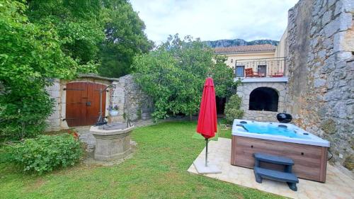 ein Garten mit Whirlpool und Sonnenschirm in der Unterkunft Villa Bartola in Grižane