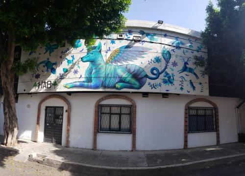 a building with a painting of a cat on it at HERMILA Tlalpan in Mexico City