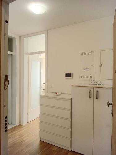a kitchen with white cabinets and a white refrigerator at Apartman Anny in Široki Brijeg