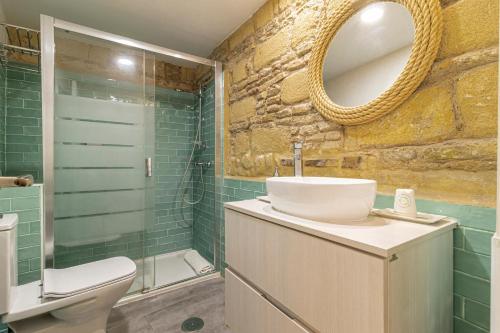 a bathroom with a sink and a toilet and a mirror at Exclusive Boutique in Jerez de la Frontera