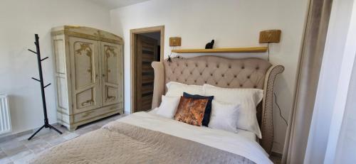 a bedroom with a large bed with a wooden headboard at Kapitány MP Art Luxury Apartman in Balatonboglár