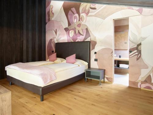 a bedroom with a bed with a painting on the wall at Garda Sporting Club Hotel in Riva del Garda