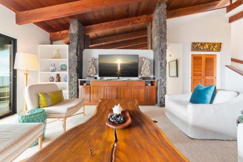a living room with a couch and a table at Aloha Casa Miramar by SkyRun Kona Coast in Kailua-Kona