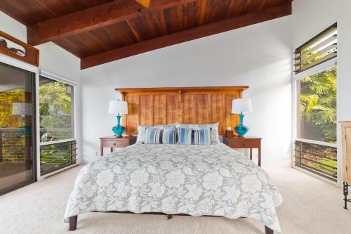 a bedroom with a large bed and two windows at Aloha Casa Miramar by SkyRun Kona Coast in Kailua-Kona