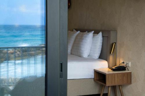 a bedroom with a bed with a view of the ocean at Curacao Avila Beach Hotel in Willemstad